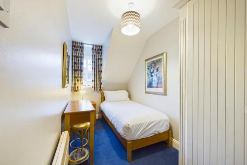 a small bedroom with a bed and a table at Faithlegg Mews, Faithlegg in Waterford