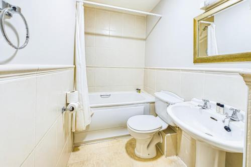 a white bathroom with a toilet and a sink at Faithlegg Mews, Faithlegg in Waterford
