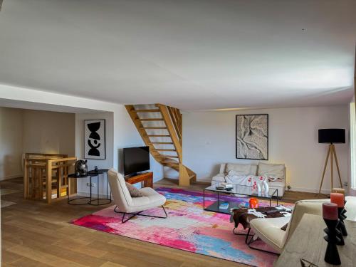 a living room with a couch and a staircase at Maison Châteaux Lavandes in Grignan