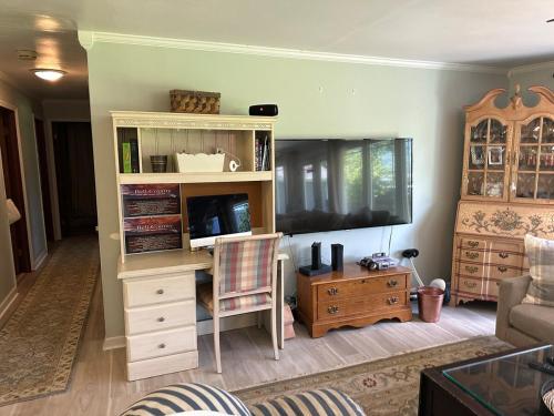 ein Wohnzimmer mit einem Entertainment-Center und einem TV in der Unterkunft Minutes from LMU, ARH, and Cumberland Gap National Historic Park, Laurel Cove Music Festival, and Pine Mountain State Resort Park in Middlesboro