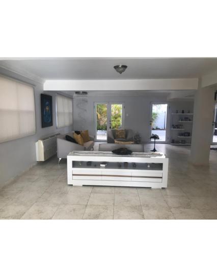 a living room with a white couch and a table at Casa Sofia in Guaynabo