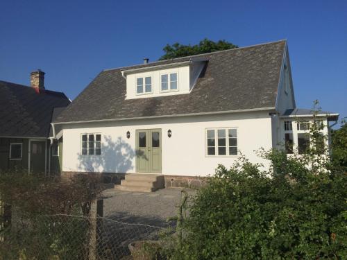 a white house with a green door at Lyckås Gårds Gästboende in Höganäs