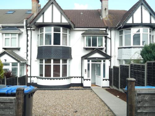 a white house with a white door and a fence at Modern 3-Bedroom Retreat Just Steps from Wembley Stadium in London