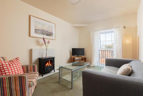 a living room with a couch and a fireplace at Discovery Accommodation in Whitby