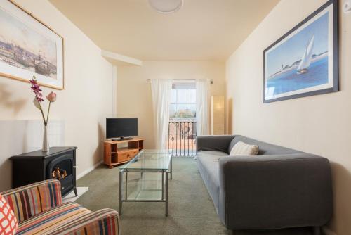 a living room with a couch and a fireplace at Discovery Accommodation in Whitby