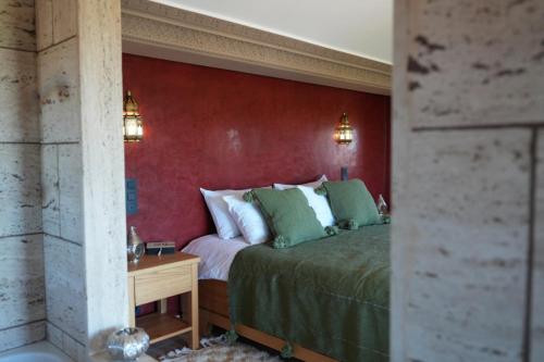 a bedroom with a bed and a red wall at Maison d'hôtes Errafiqi in Safi