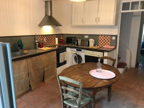 une cuisine avec une table, un évier et une cuisinière dans l'établissement Lubéron Grde Maison de village avec terrasse 4 chambres doubles, à Saint-Martin-de-Castillon