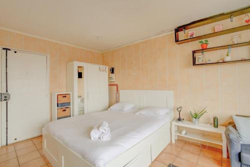 une chambre avec un lit blanc avec des serviettes dessus dans l'établissement Rêveries au Pré-Saint-Gervais, à Le Pré-Saint-Gervais