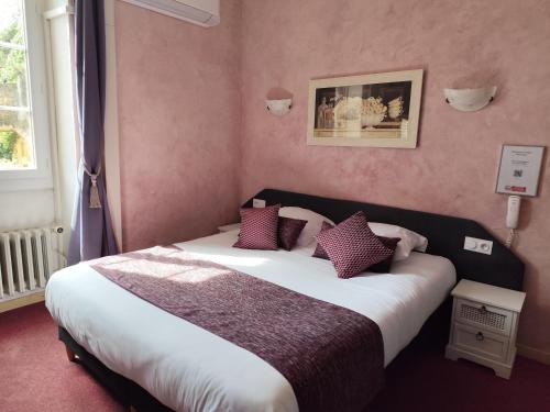 une chambre avec un grand lit aux murs violets dans l'établissement Hôtel Saint Jean, à Orange