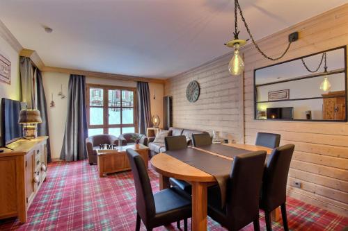 un salon avec une table et des chaises en bois dans l'établissement Appartement 60 m2 grand balcon plein sud ARC 1950, piscine, sauna, hammam, à Arc 1950