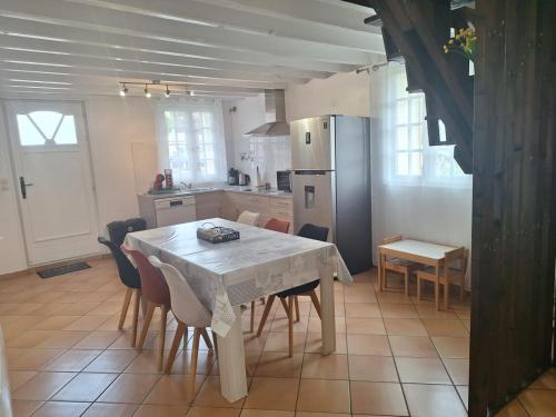 a kitchen with a table and chairs and a refrigerator at L'Auberge de la fontaine in Fontaine-sous-Jouy