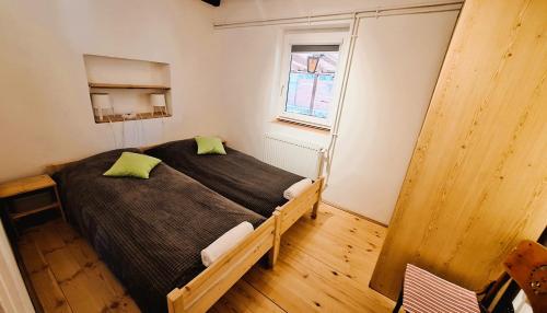 a bedroom with a bed with green pillows on it at Két Macska Vendégház, Piliscsaba in Piliscsaba