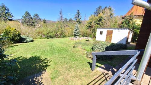 a yard with a fence and a white building at Két Macska Vendégház, Piliscsaba in Piliscsaba