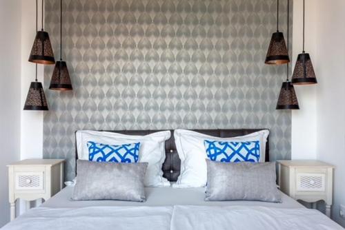 a bedroom with a bed with blue and white pillows at Azur Villa - Panoramic Escape in Balatonalmádi