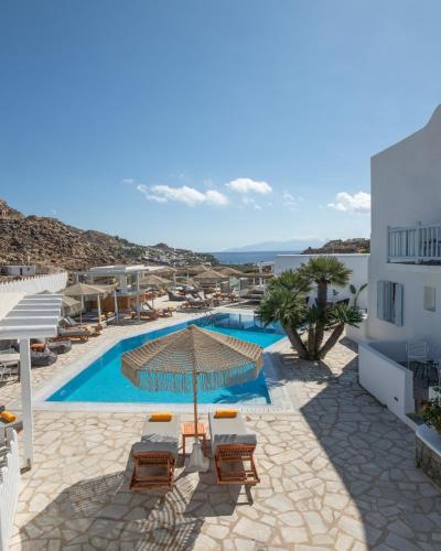 a view of a pool with chairs and an umbrella at Paradise View Hotel in Paradise Beach