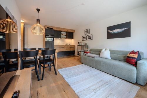a living room with a couch and a table at Höfi Studio by Arosa Vacations, Direkt vor den Skiliften Arosa-Hörnli in Arosa