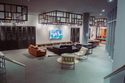 a living room with couches and chairs and a tv at Opta Coliving Punta Carretas in Montevideo