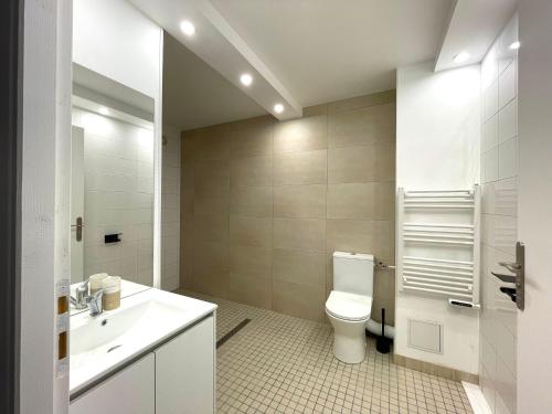 une salle de bain blanche avec des toilettes et un lavabo dans l'établissement Agréable 2 chambres avec Parking Proche Orly et T12, à Morangis