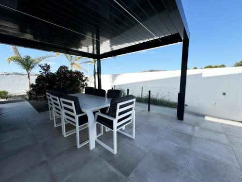 a white table and chairs on a patio with the ocean at Luxury Villa Felicita Moraira in Moraira