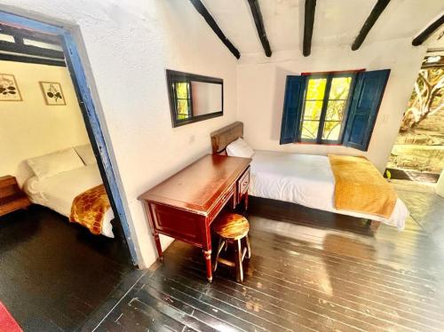 a bedroom with a desk and a bed and window at Botanico Hostel in Bogotá