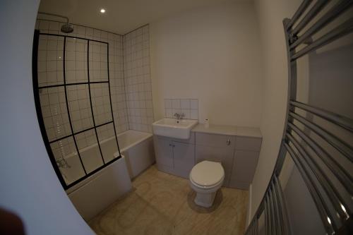 Un baño pequeño con inodoro y lavabo. en The Cattleyard, en Hambledon