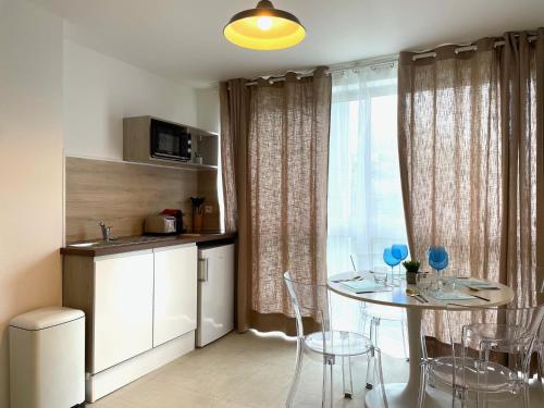 une cuisine et une salle à manger avec une table et des chaises dans l'établissement Agréable 2 chambres avec Parking Proche Orly et T12, à Morangis