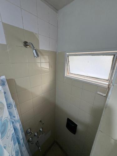 a bathroom with a shower with a window at Jujuy Hostel in San Salvador de Jujuy