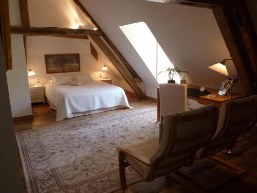 an attic bedroom with a bed and a chair at Le Clos Saint Nicolas in Château-Renard
