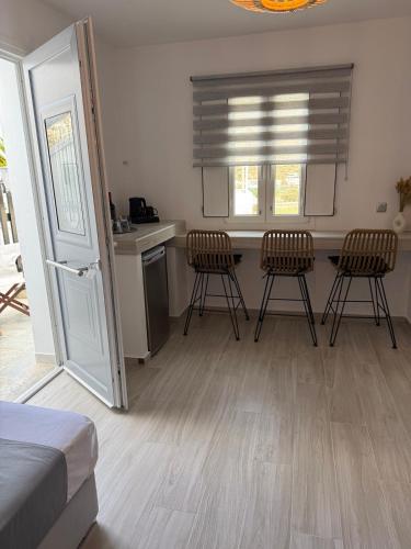 a bedroom with a kitchen with chairs and a table at Chrysa House in Kamarai