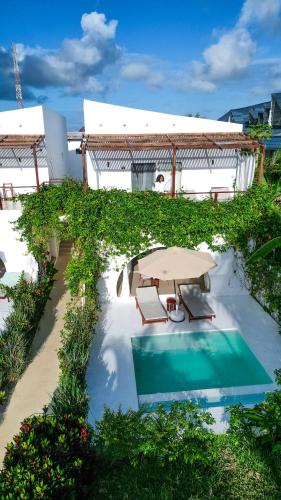 a patio with a table and chairs and a pool at Alma Boutique Hotel in Jambiani