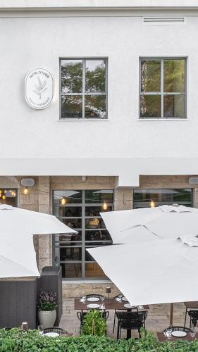 a building with white umbrellas and tables and a clock at Hotel Carmel  in Haifa