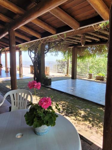 a table with pink flowers on it under a pergola at Rancho Smaniotto 1783 in Dois Irmãos