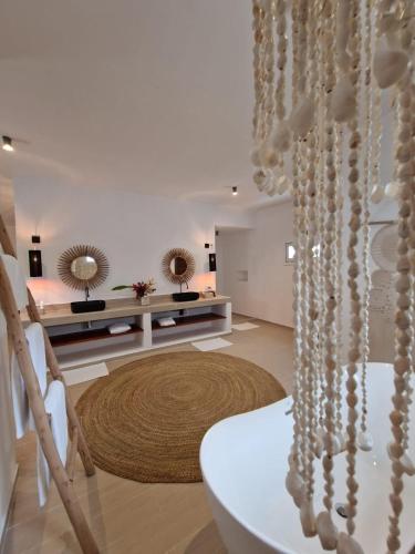 a white living room with a table and a mirror at Alma Boutique Hotel in Jambiani