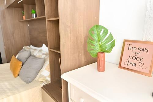 a plant sitting on a white table in a room at ASA | Loft Prático e Aconchegante | Centro Itajaí in Itajaí