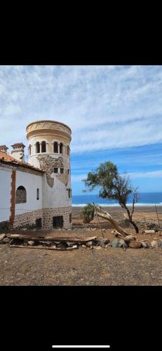 a building in the middle of a desert with a tree at Estocolmo Lovely in Gran Tarajal