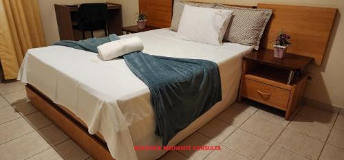 a bedroom with a bed with a blanket on it at Prive das Thermas - 301B in Caldas Novas