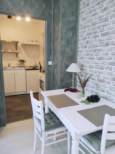 une table blanche et des chaises dans une cuisine dans l'établissement Nid douillet avec jacuzzi privé, à La Celle-sous-Gouzon