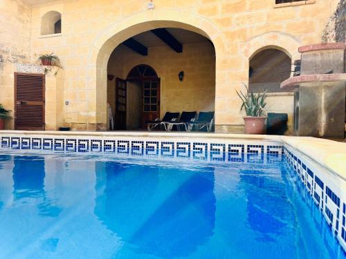 a large swimming pool in a building with a house at 4 Bedroom Holiday Home with Private Pool in Xagħra