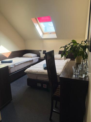 a room with two beds and a table and a window at Zajazd CISZA in Ciągowice