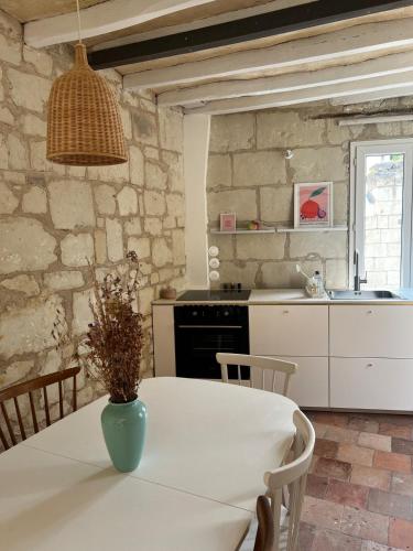 une cuisine avec une table avec un vase dessus dans l'établissement La maison familiale des bords de Loire, à Turquant