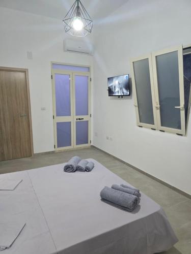 a white room with two towels on a bed at Casa Vacanza S Elia in Veglie