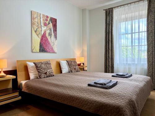 a bedroom with a large bed with a window at Barbacan Apartments in the Old Town in Vilnius