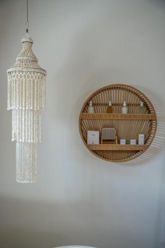 a chandelier and a mirror on a wall at Alma Boutique Hotel in Jambiani