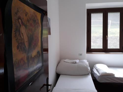 a room with two beds and a window at Ospitalità Frate Sole entire house in Caiano