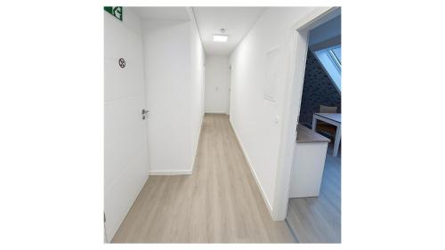 a hallway with white walls and a wooden floor at Ferienwohnung Danny in Marienheide