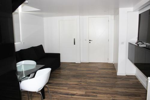 a living room with a black couch and a glass table at Loft Prestige in Leiria
