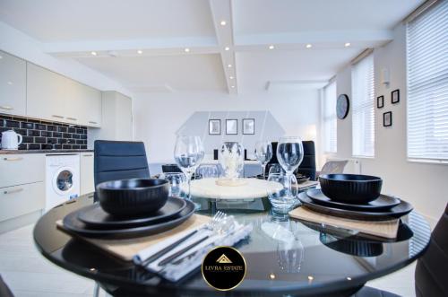 a dining room with a table with wine glasses at Stylish 1 bed Apt By Livra Estate Short Lets & Serviced Accommodation Sutton With Free Parking in Sutton