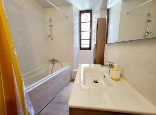 une salle de bain blanche avec un lavabo et une baignoire dans l'établissement La bulle à Thueyts Proche Pont du diable, à Thueyts