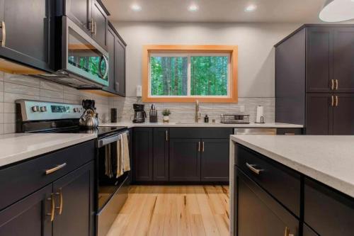 a kitchen with black cabinets and a wooden floor at 15GS - Hot Tub - WIFI- Pets Ok in Deming