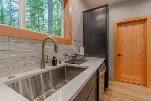 a kitchen with a stainless steel sink and a black refrigerator at 15GS - Hot Tub - WIFI- Pets Ok in Deming